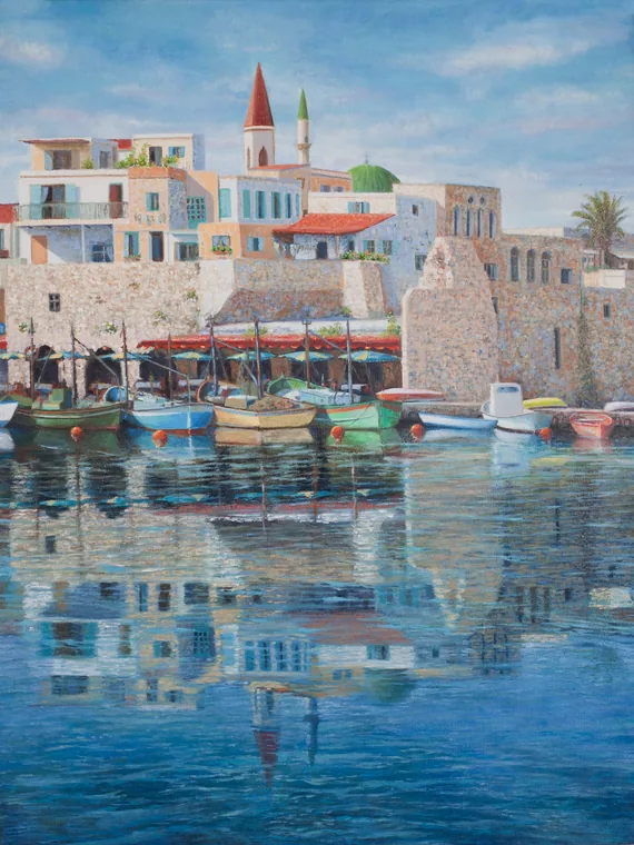 Boats and old Acre buildings reflected in calm harbor water.