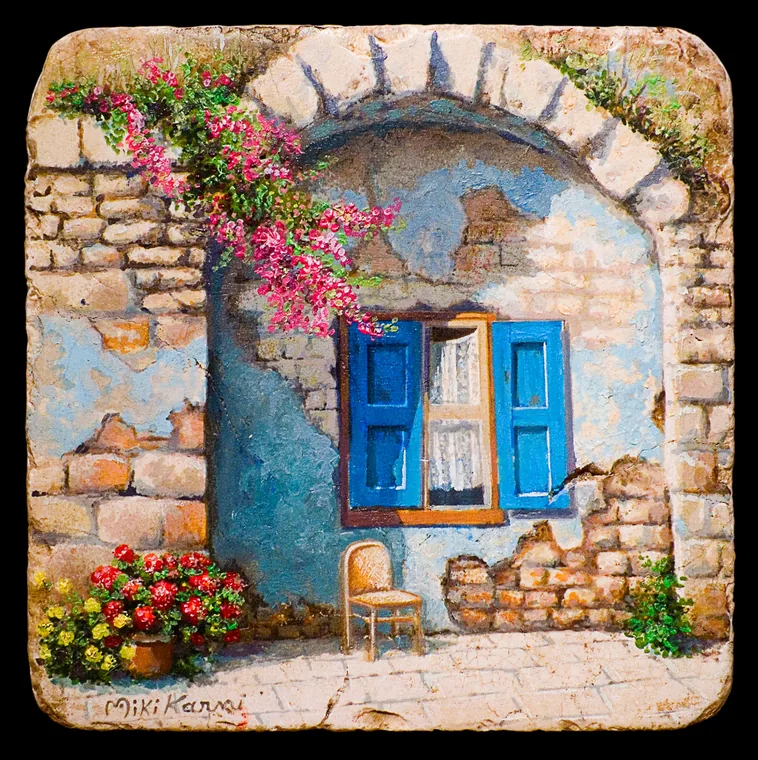 Blue window beneath a stone arch with pink flowers.