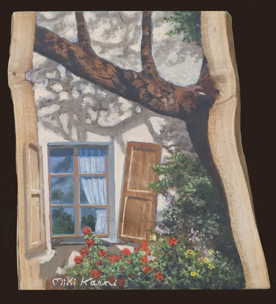 Rustic window and flowers beneath a large tree branch.
